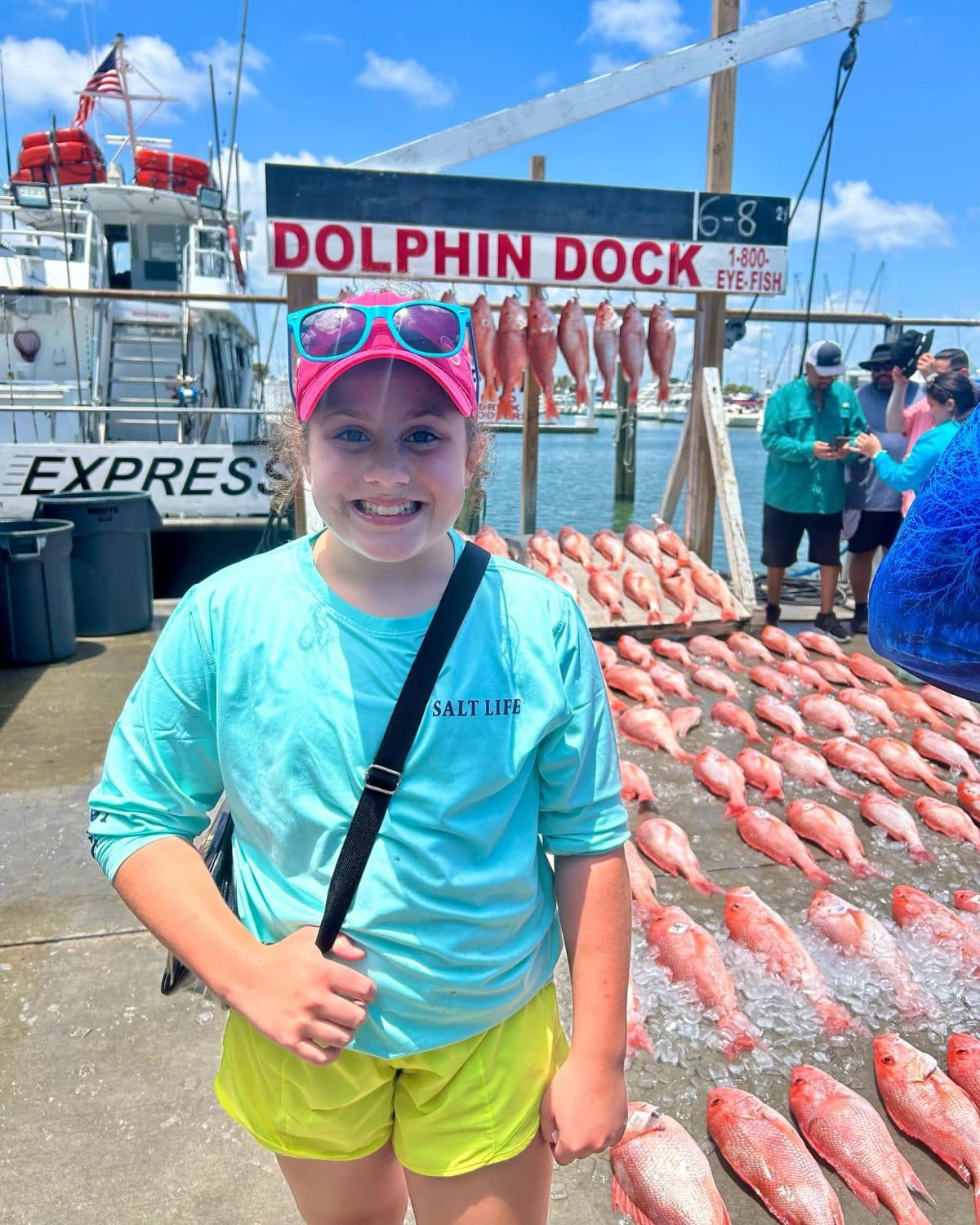 A young angler at the dock with a red snapper caught on a Dolphin Dock trip